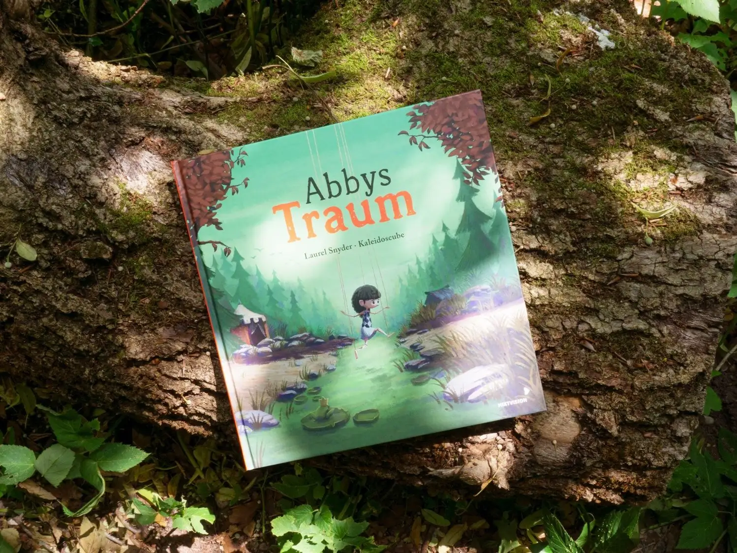 The printed book resting on mossy tree bark
