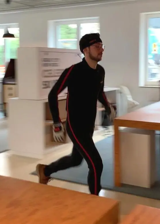 A team member in a motion-capture suit mid-stride in the office